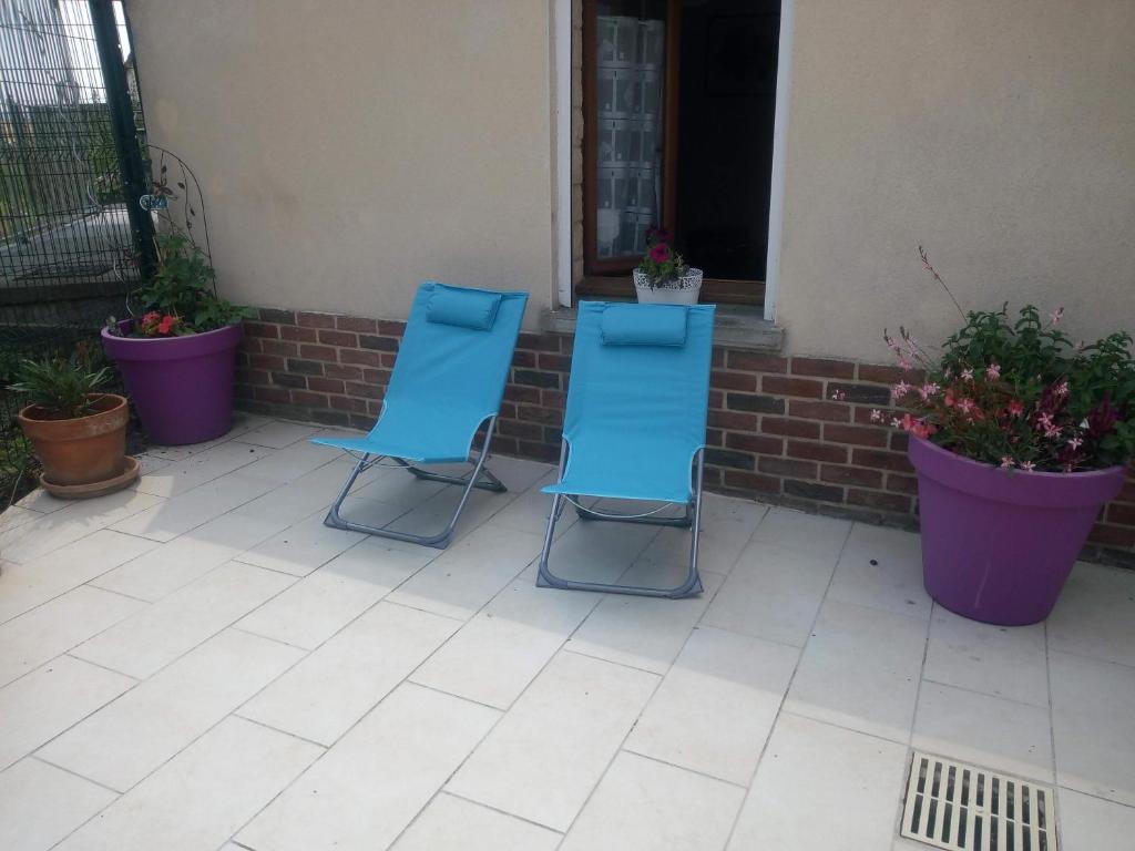 zwei blaue Stühle auf einer Terrasse mit Pflanzen in der Unterkunft Le patio de Mimi in Oisy-le-Verger