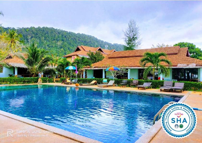 a swimming pool in front of a house at Banana Beach Resort in Ko Lanta