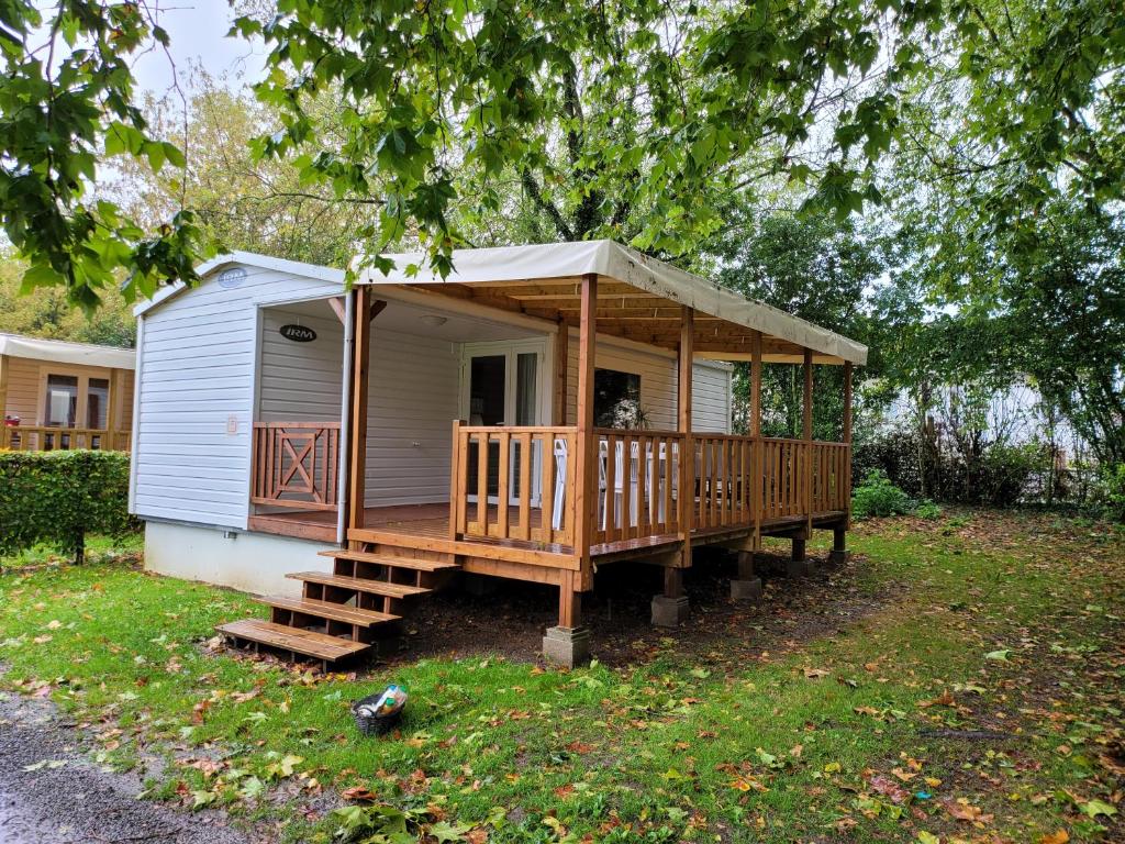 a small house with a porch and a deck at Camping Le Brochet in Péronne
