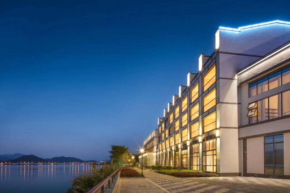 um edifício ao lado de uma massa de água em voco Thousand Island Lake, an IHG Hotel em Chun'an