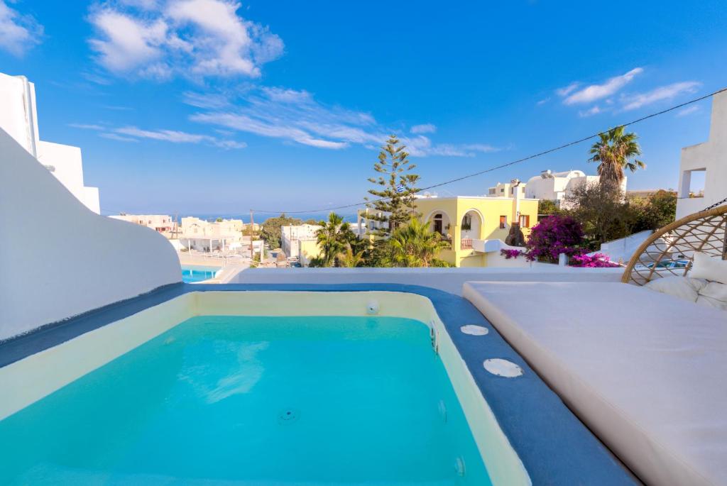 a swimming pool in a villa with a view at The Muses of Santorini Private Jacuzzi Suites in Vóthon