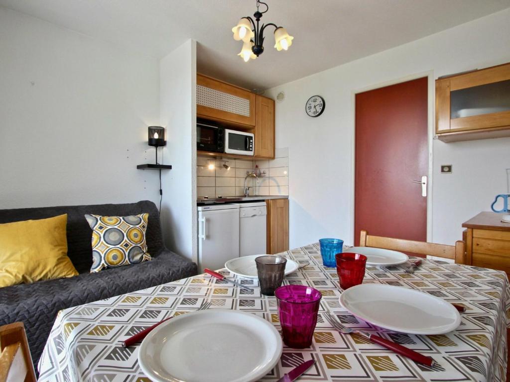 ein Wohnzimmer mit einem Tisch mit Tellern darauf in der Unterkunft Studio Chamrousse, 1 pièce, 6 personnes - FR-1-340-208 in Chamrousse