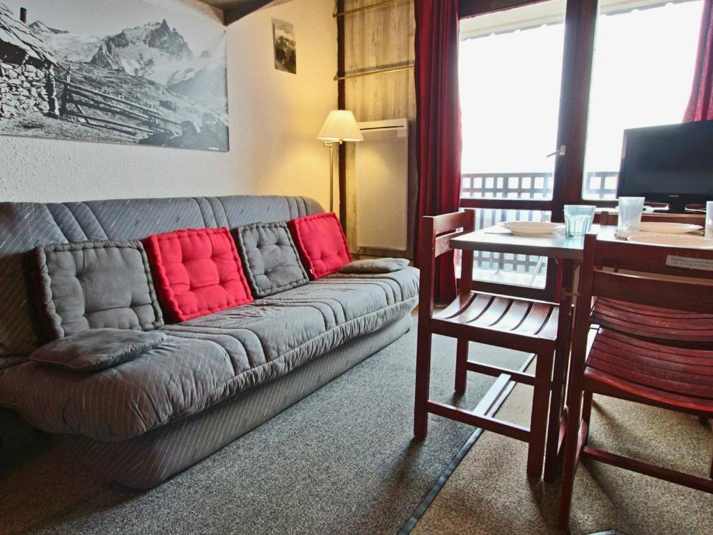 ein Wohnzimmer mit einem Sofa mit roten Kissen darauf in der Unterkunft Studio Chamrousse, 1 pièce, 4 personnes - FR-1-340-50 in Chamrousse