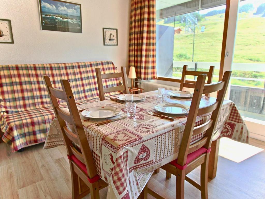 a dining room with a table and chairs and a window at Studio Chamrousse, 1 pièce, 4 personnes - FR-1-340-99 in Chamrousse