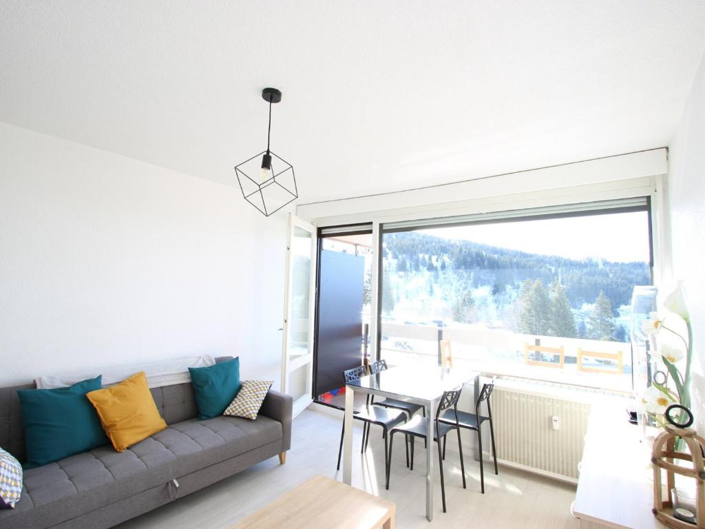 a living room with a couch and a table at Studio Chamrousse, 1 pièce, 4 personnes - FR-1-340-108 in Chamrousse