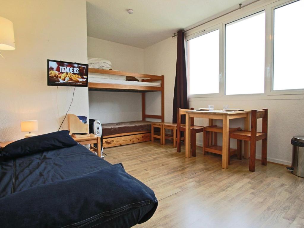 a bedroom with a bed and a desk and a table at Studio Chamrousse, 1 pièce, 3 personnes - FR-1-340-109 in Chamrousse