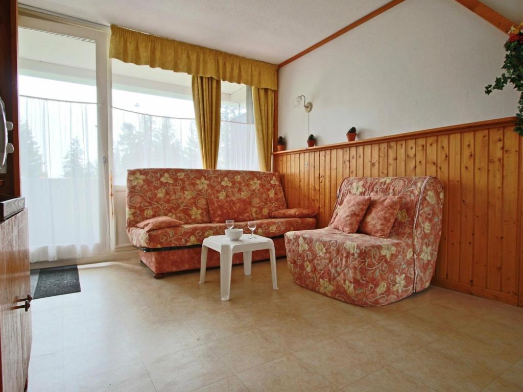 a living room with a couch and a chair and a table at Studio Chamrousse, 1 pièce, 3 personnes - FR-1-340-135 in Chamrousse