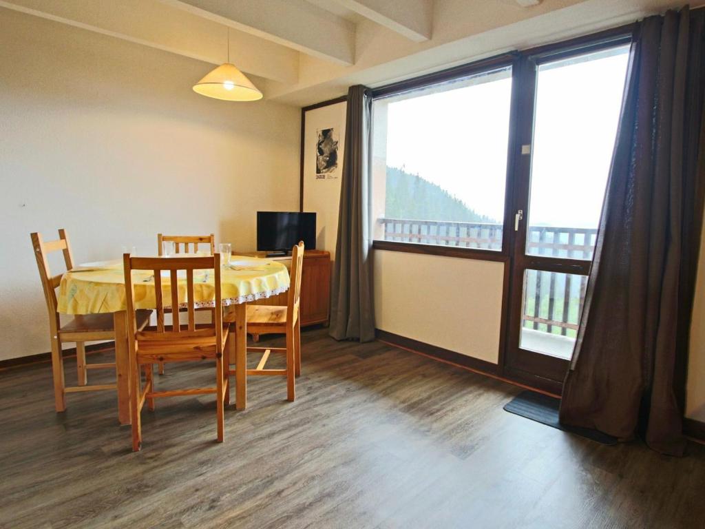 une salle à manger avec une table, des chaises et une grande fenêtre dans l'établissement Studio Chamrousse, 1 pièce, 4 personnes - FR-1-340-153, à Chamrousse