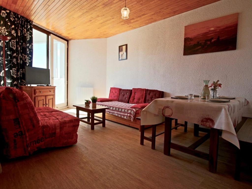 uma sala de estar com um sofá vermelho e uma mesa em Studio Chamrousse, 1 pièce, 4 personnes - FR-1-340-91 em Chamrousse