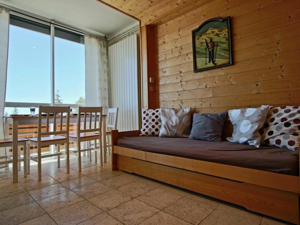 a bedroom with a bed and a table and chairs at Studio Chamrousse, 1 pièce, 4 personnes - FR-1-549-22 in Chamrousse