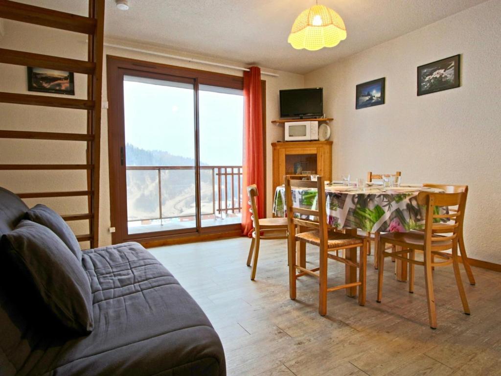 a living room with a table and chairs with a view at Appartement Chamrousse, 2 pièces, 7 personnes - FR-1-340-229 in Chamrousse