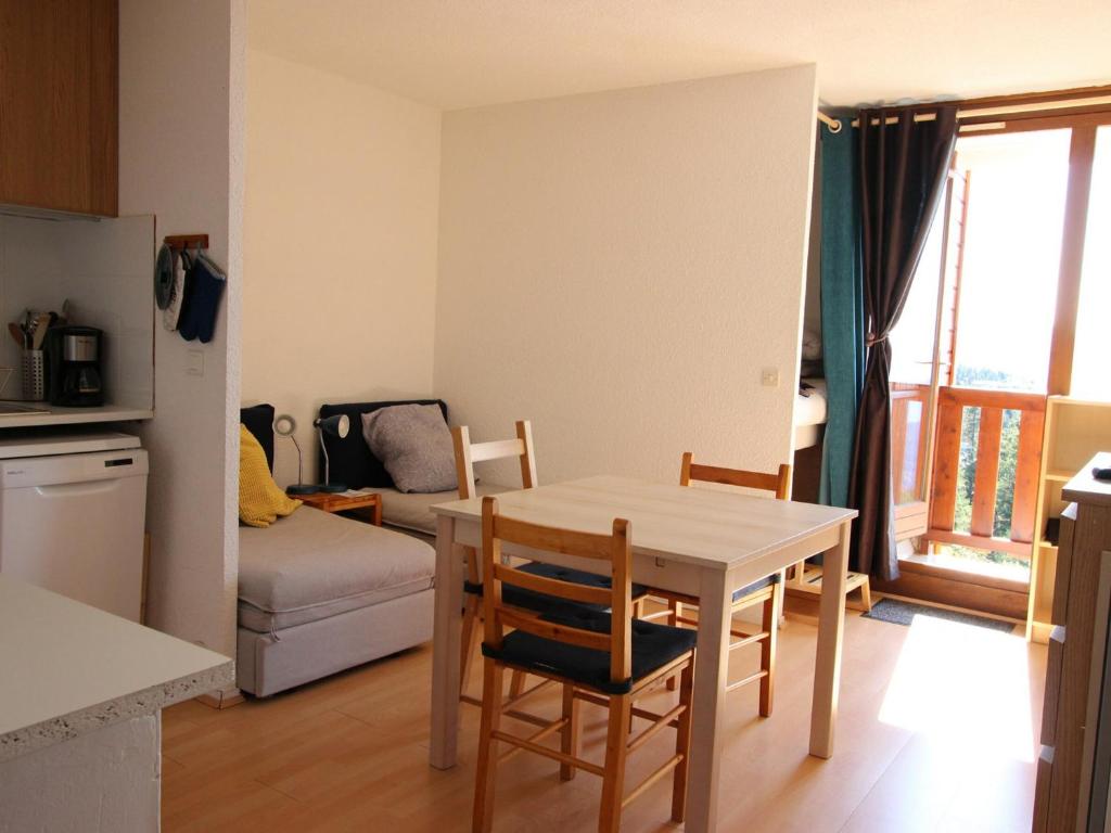 uma cozinha e sala de estar com mesa e cadeiras em Studio Chamrousse, 1 pièce, 4 personnes - FR-1-340-199 em Chamrousse