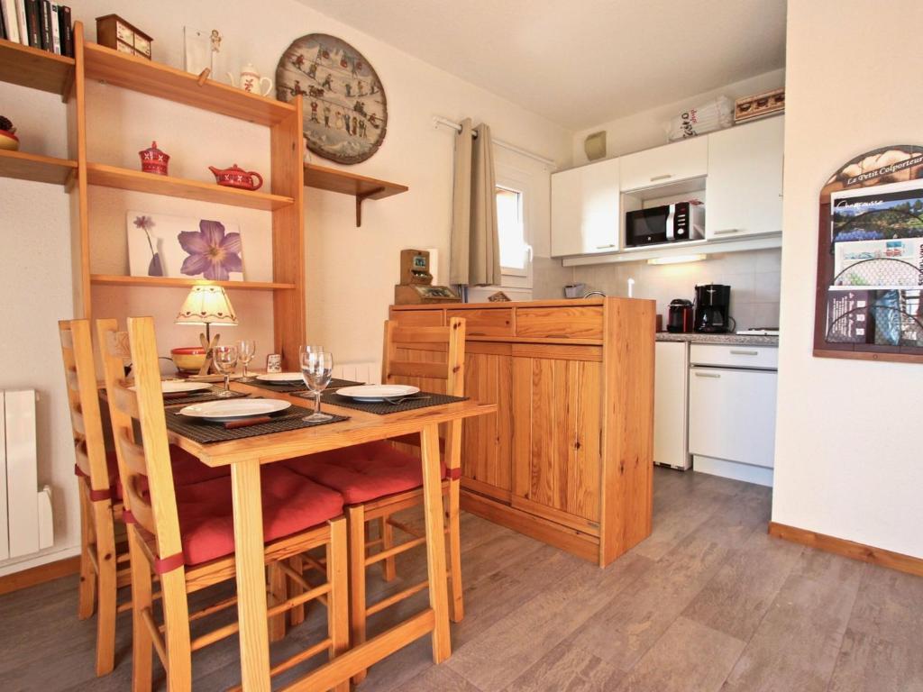 a kitchen and dining room with a wooden table and chairs at Appartement Chamrousse, 2 pièces, 4 personnes - FR-1-340-210 in Chamrousse