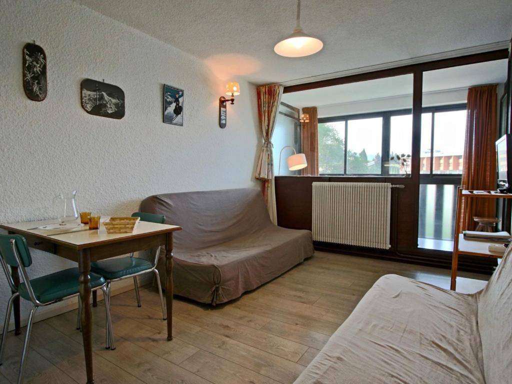 a room with a bed and a table and a bed and a desk at Studio Chamrousse, 1 pièce, 3 personnes - FR-1-549-35 in Chamrousse