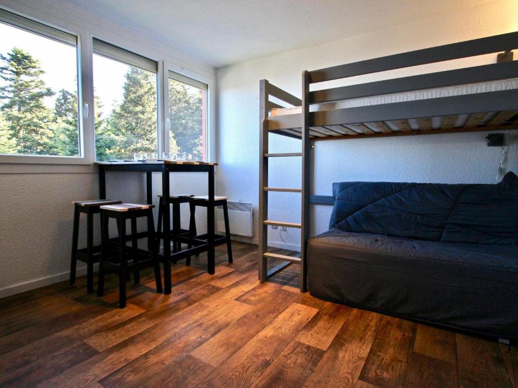 a bedroom with a bunk bed and a table and chairs at Studio Chamrousse, 1 pièce, 3 personnes - FR-1-549-12 in Chamrousse