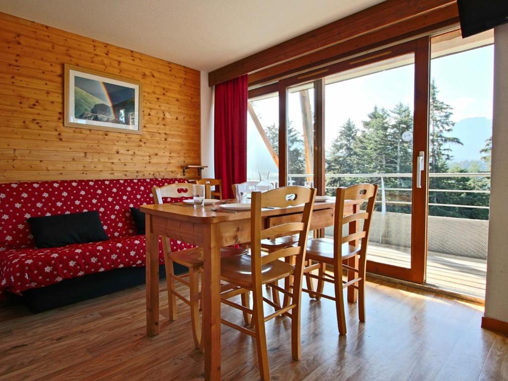 a dining room with a table and chairs and a couch at Appartement Chamrousse, 3 pièces, 6 personnes - FR-1-549-1 in Chamrousse