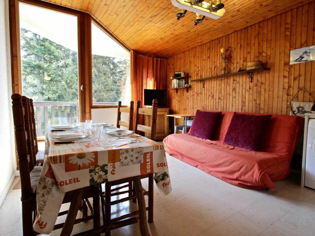 a living room with a table and a couch in a room at Studio Chamrousse, 1 pièce, 4 personnes - FR-1-549-61 in Chamrousse
