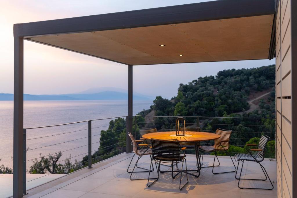 a table and chairs on a balcony with a view of the ocean at Kechria Bay Villas in Skiathos