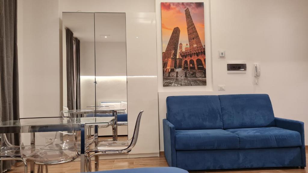 a blue couch and a glass table in a room at Giudei House Loft 2 in Bologna