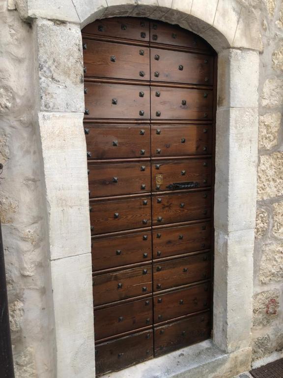 uma porta de madeira numa parede de pedra em La casa della sirena em SantʼEufemia a Maiella
