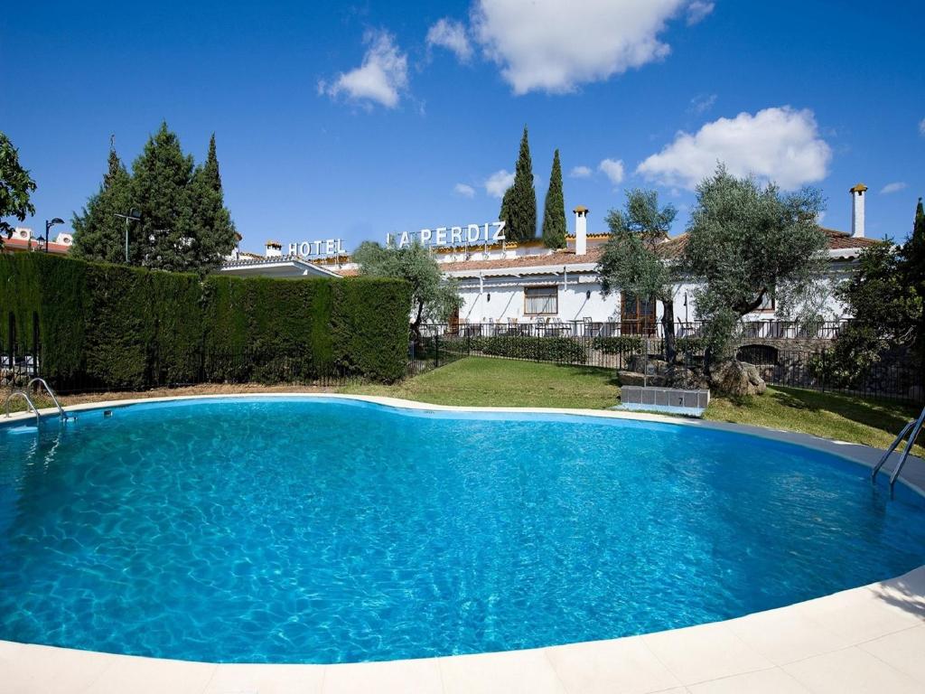 a large blue swimming pool in front of a building at Hotel la Perdiz in La Carolina