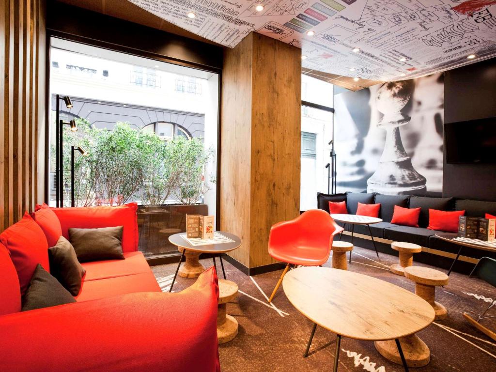 Cette chambre est dotée d'un mobilier et de tables rouges ainsi que d'une fenêtre. dans l'établissement ibis Paris Gare De L'Est TGV, à Paris