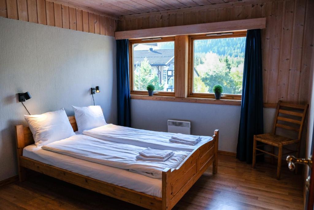 a bedroom with a bed and a window and a chair at Hemsetunet Apartments in Hemsedal