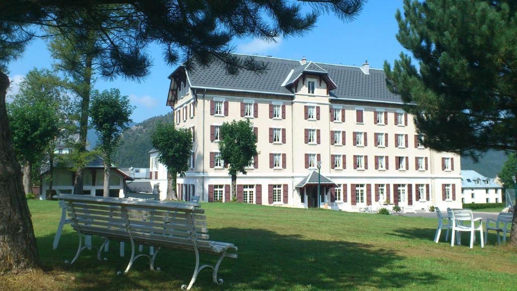 a large building with a park bench in front of it at Best Western Grand Hotel de Paris & Spa in Villard-de-Lans