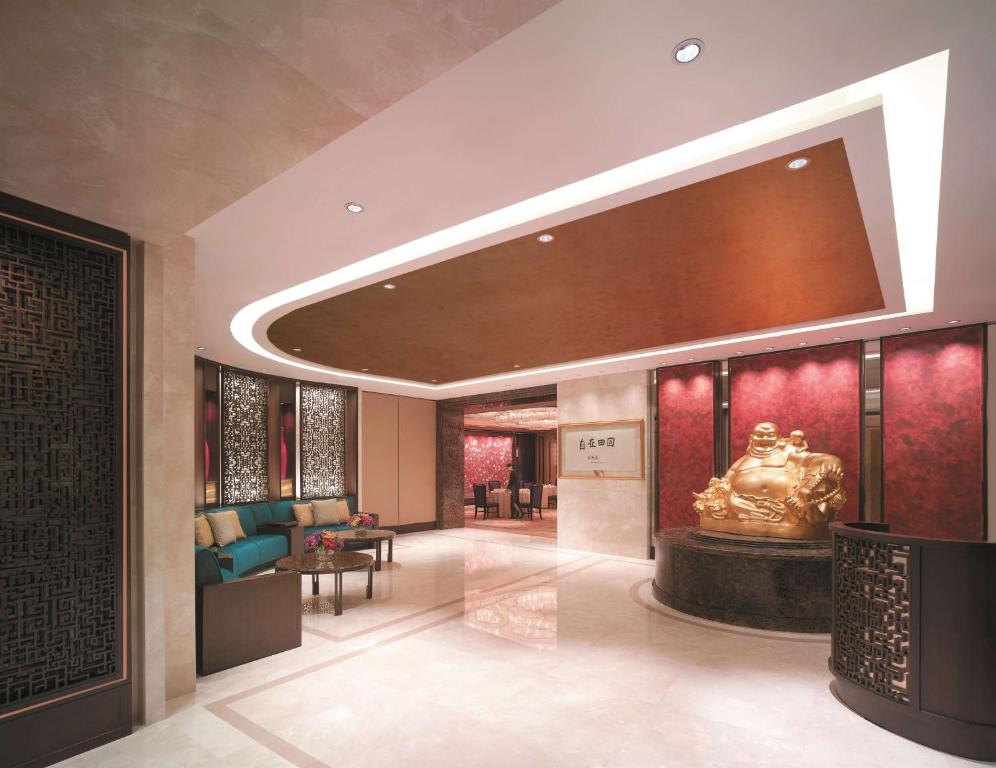 A polished lobby lounge with a Buddha statue and Asian-inspired details.