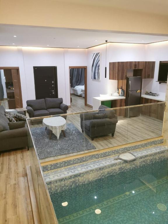 a living room with a swimming pool and a living room at Private Sand Bond in Al Raka