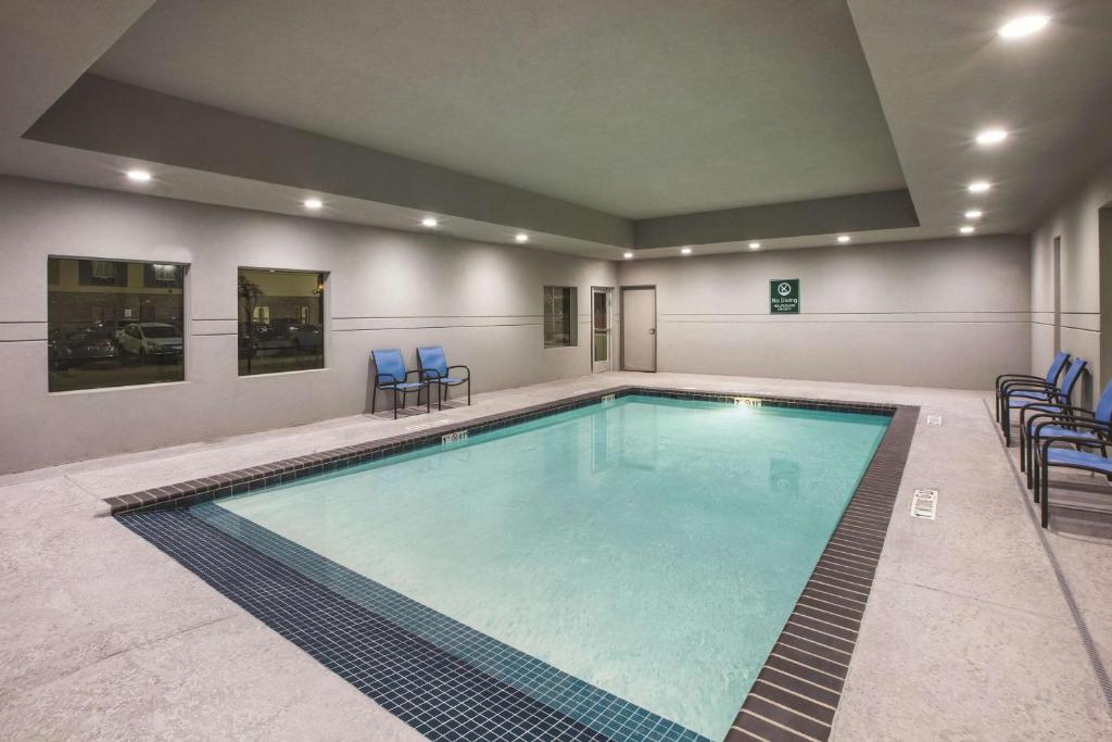 a large swimming pool with blue chairs in a building at La Quinta by Wyndham Lubbock South in Lubbock
