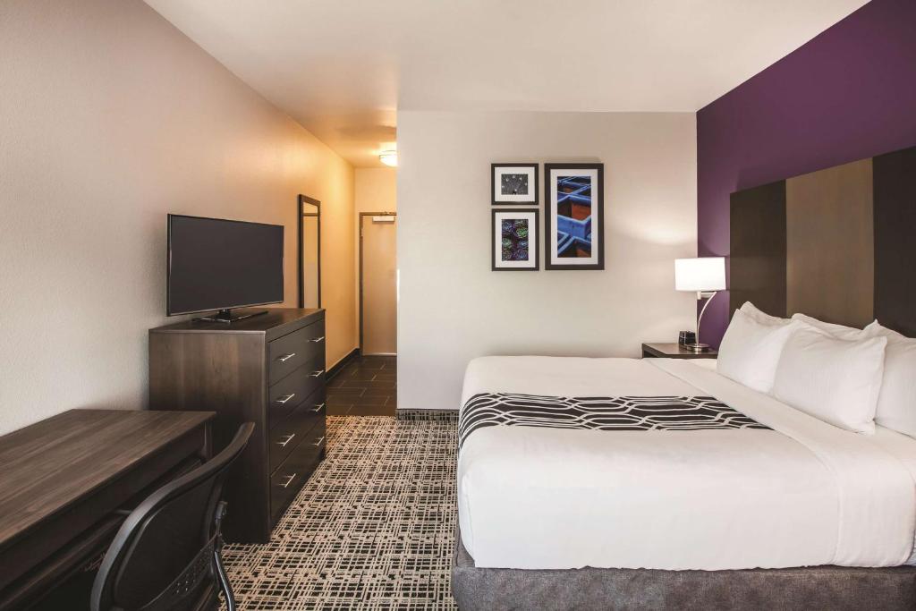 a hotel room with a bed and a flat screen tv at La Quinta by Wyndham Lubbock South in Lubbock