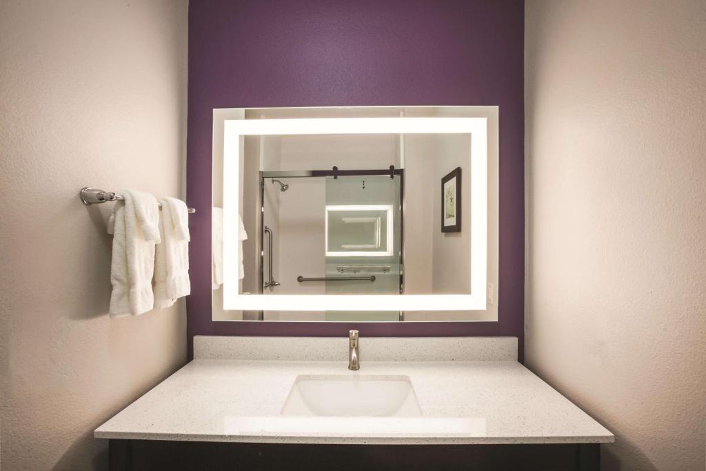 a bathroom with a sink and a mirror at La Quinta by Wyndham Lubbock South in Lubbock