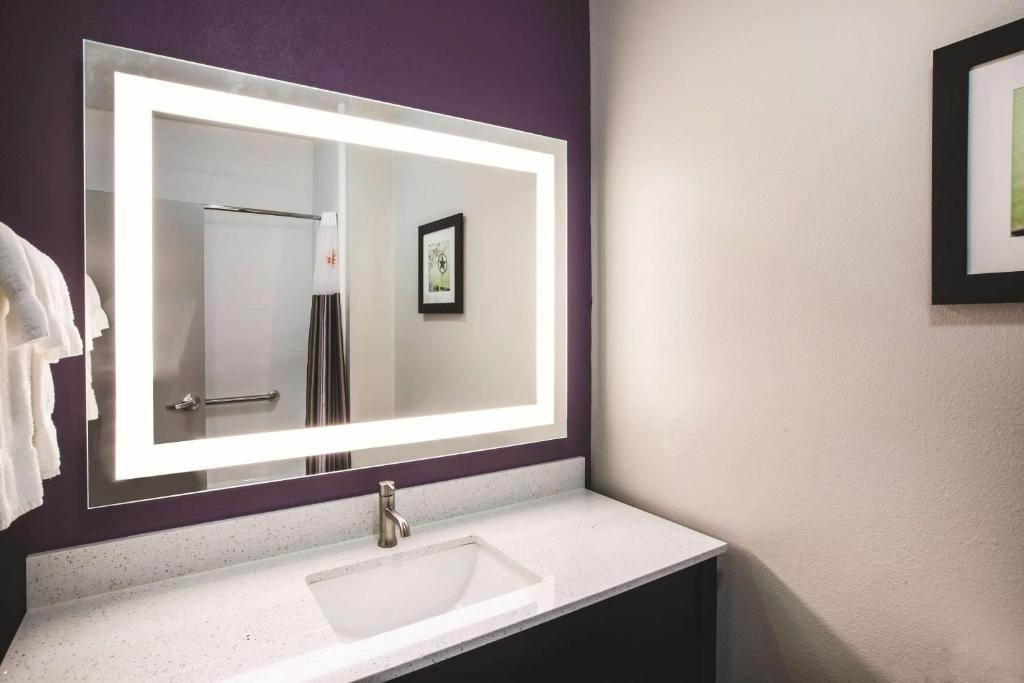 a bathroom with a sink and a mirror at La Quinta by Wyndham Lubbock South in Lubbock