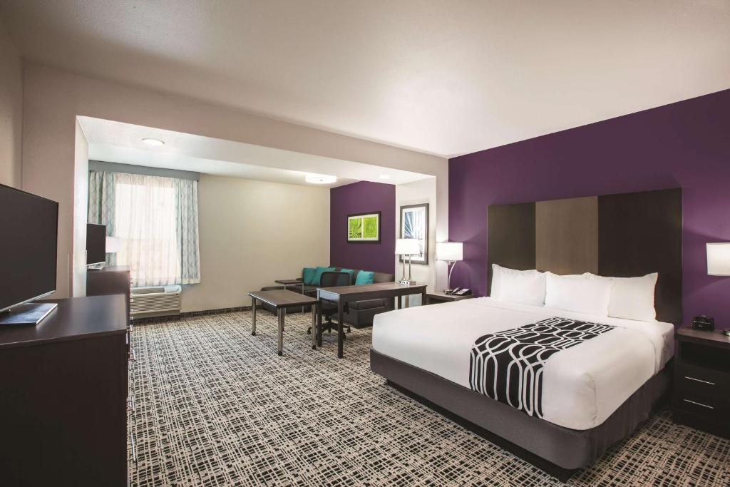 a hotel room with a large bed and a desk at La Quinta by Wyndham Lubbock South in Lubbock