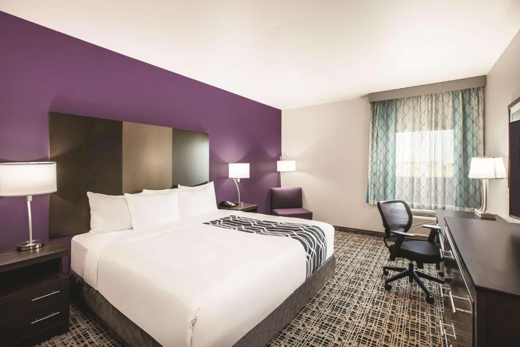 a hotel room with a large bed and a desk at La Quinta by Wyndham Lubbock South in Lubbock