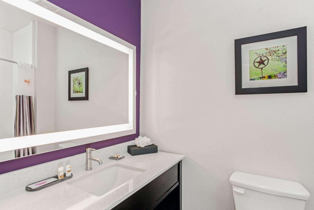 a bathroom with a white sink and a mirror at La Quinta by Wyndham Lubbock South in Lubbock