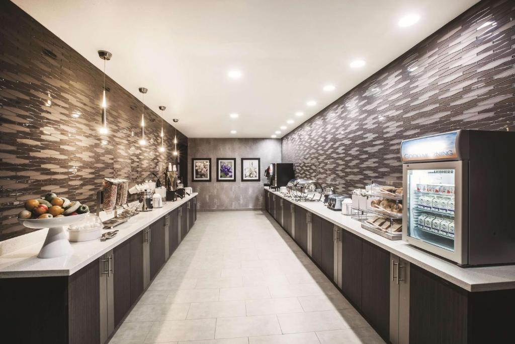 a restaurant with a long line of counters with food at La Quinta by Wyndham Lubbock South in Lubbock