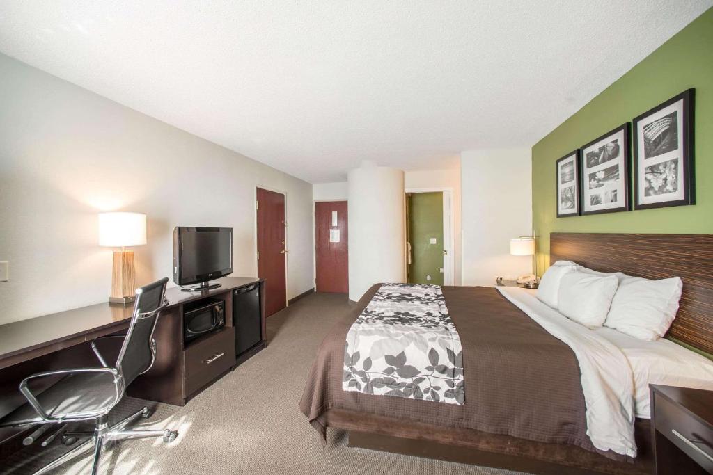 LarkdaleにあるSleep Inn Decatur I-72のベッド、デスク、テレビが備わるホテルルームです。