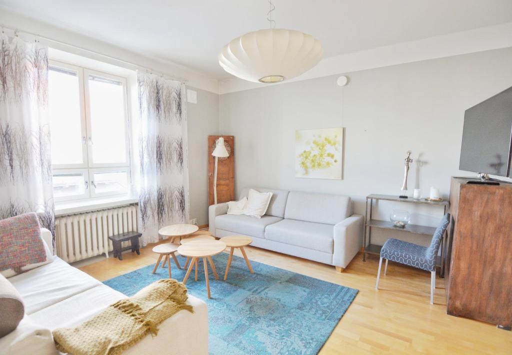 uma sala de estar com um sofá e uma mesa em HOMELY - City Apartment 50m2 em Helsinque