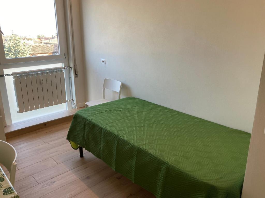 a bedroom with a green bed and a window at Guido's Apartment Villa Romana in Desenzano del Garda