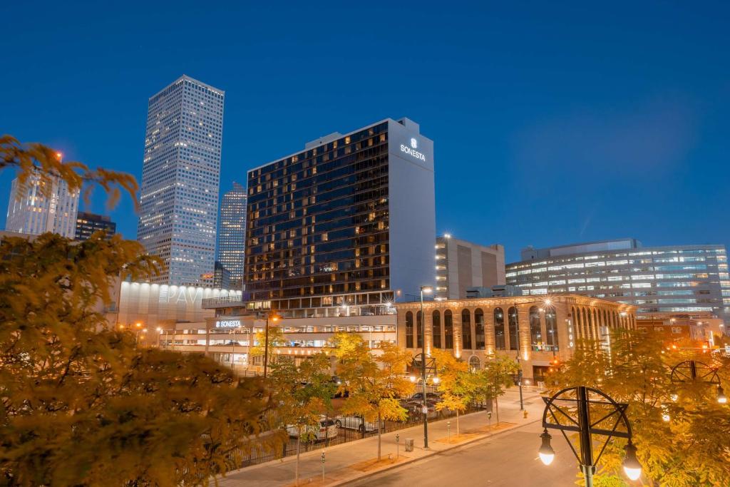een skyline van de stad 's nachts met hoge gebouwen bij Sonesta Denver Downtown in Denver