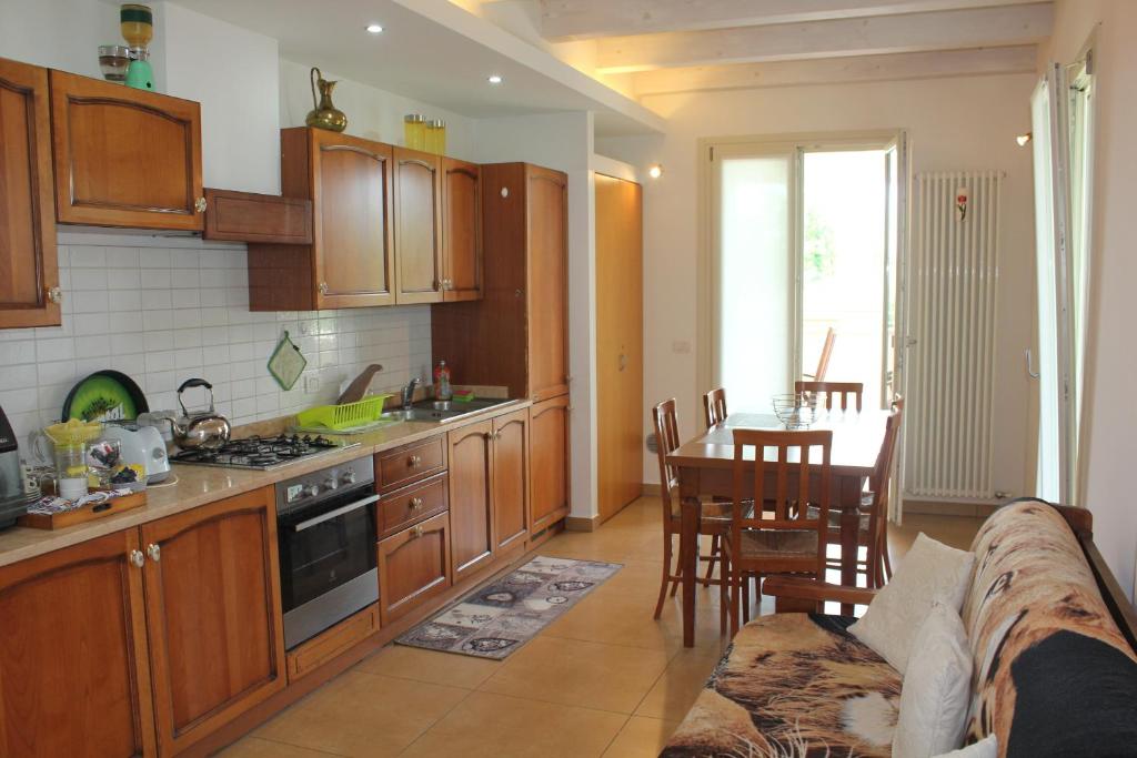 une cuisine avec des placards en bois et une salle à manger avec une table dans l'établissement Villa Paradiso del Garda Vista-Verde, à Bardolino