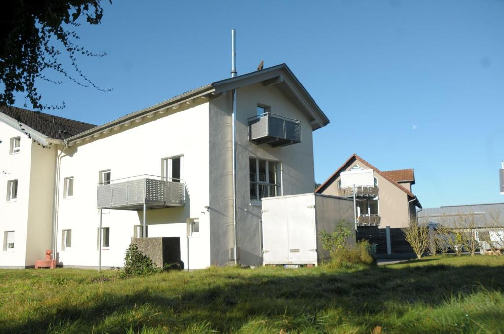 Habitación con balcón y vistas al exterior de un edificio blanco. en La Gelataia, en Münstertal