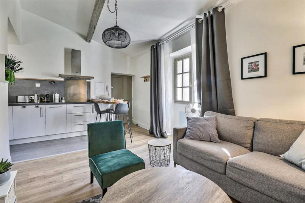 un salon avec un canapé et une cuisine dans l'établissement L'Exception, à Nîmes