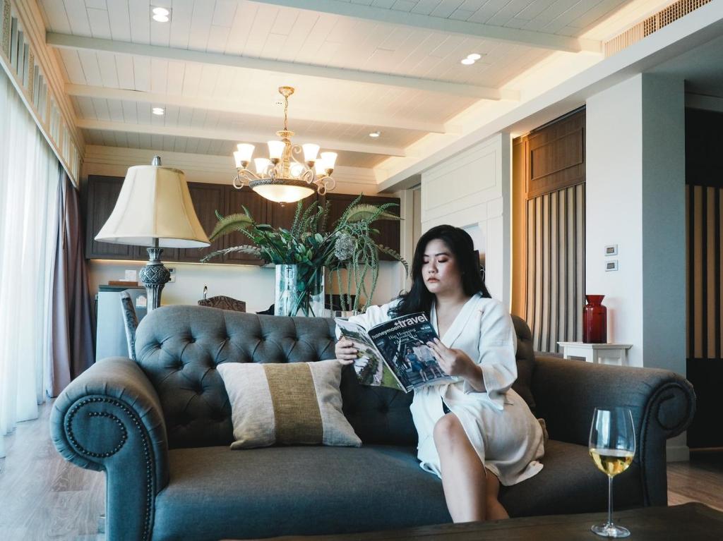 A tufted leather sofa creates a furnished reading corner beside tall windows.