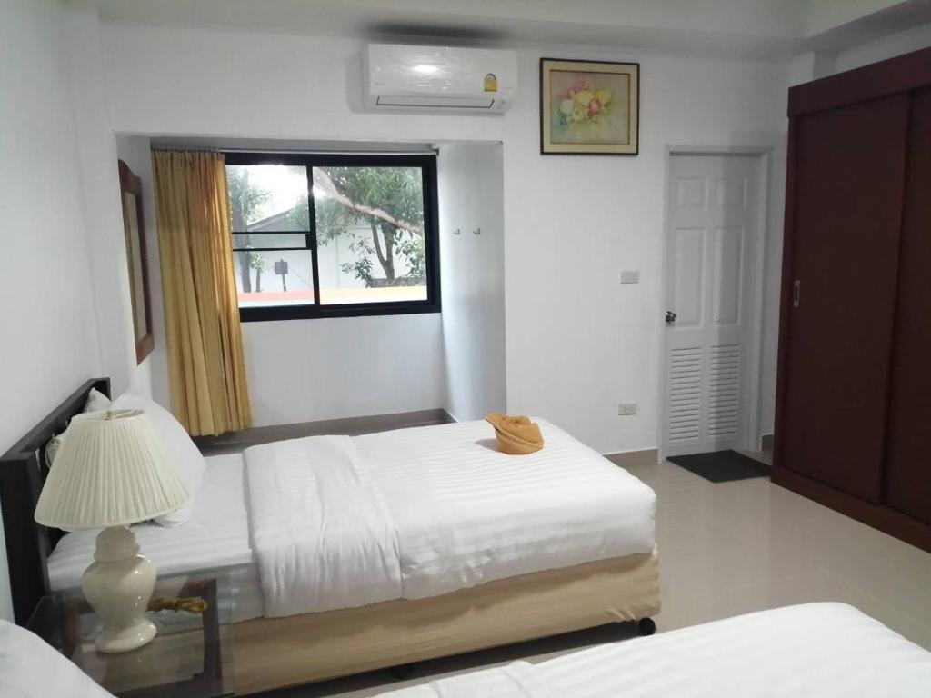 a bedroom with two beds and a window at มุก&พลอย เรสซิเดนซ์ in Sattahip