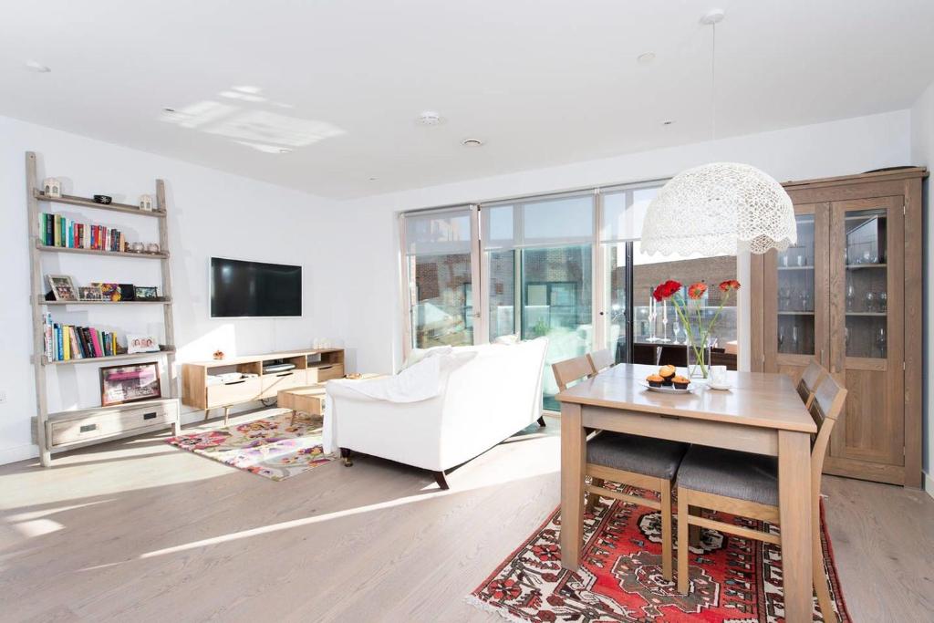 ロンドンにあるStunning 1 Bedroom Apartment in Central Londonのリビングルーム(白いソファ、テーブル付)