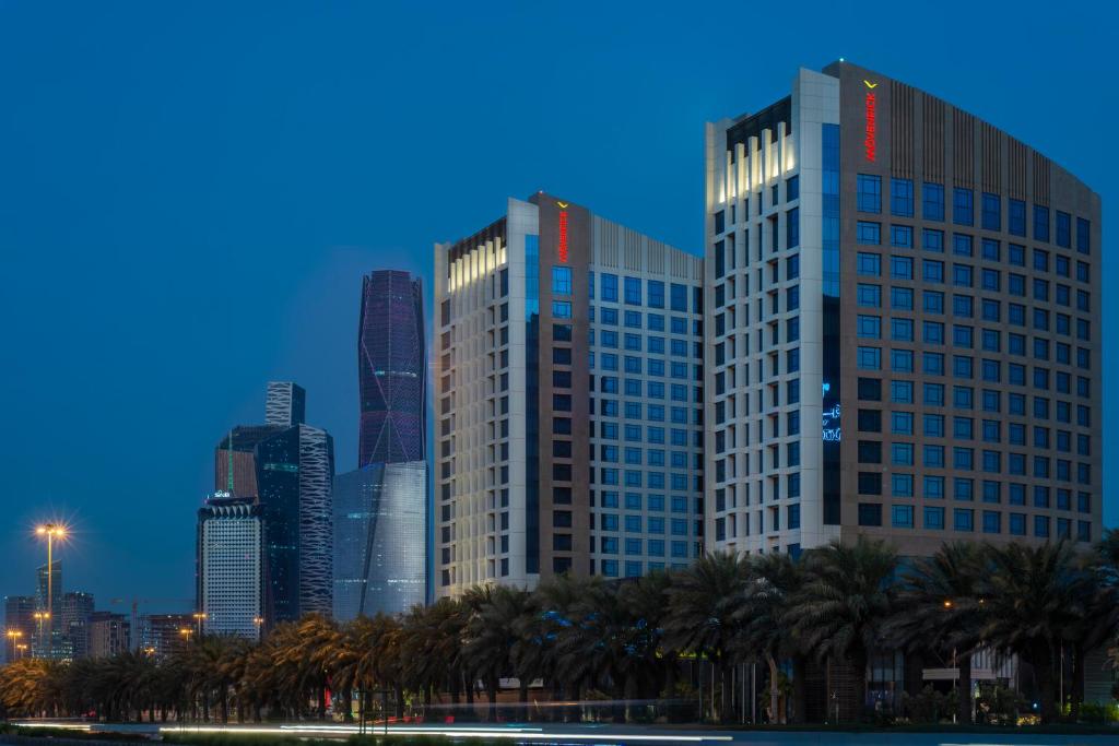 a city skyline with palm trees and buildings at Movenpick Hotel and Residences Riyadh in Riyadh