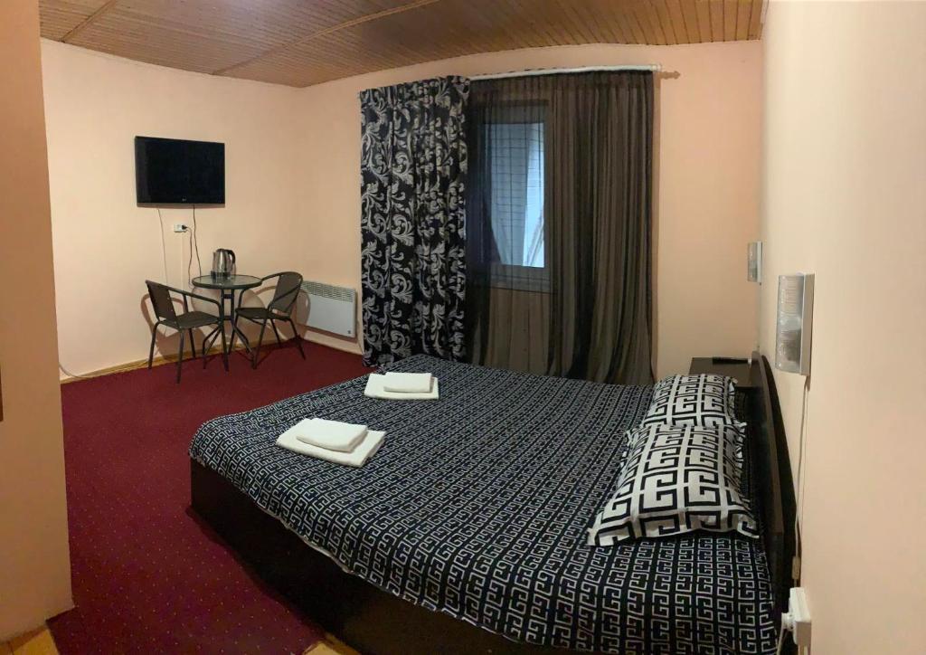 ein Hotelzimmer mit einem Bett und einem Tisch in der Unterkunft Mini-Hotel Sakvoyage in Czernowitz